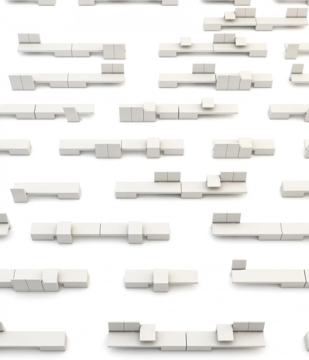 Eine Anordnung von zahlreichen weißen rechteckigen Blöcken unterschiedlicher Länge und Höhe auf einer weißen Oberfläche.