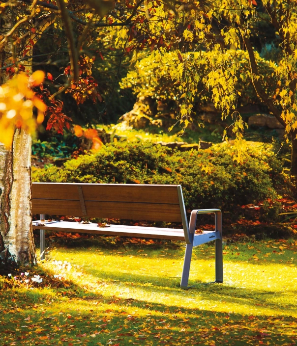 Eine Parkbank in einem üppigen, grünen Garten.