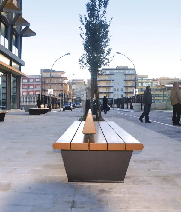 Eine moderne städtische Umgebung mit einer langen Bank im Vordergrund.