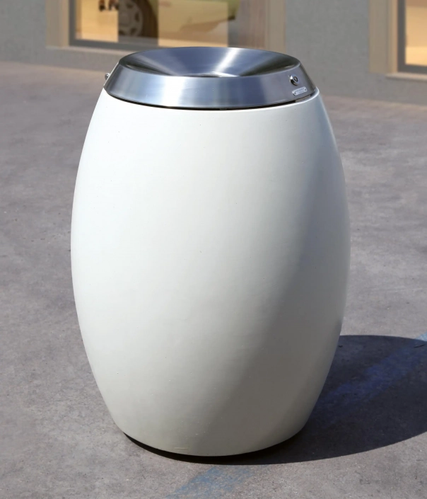 Weißer, ovaler Abfallbehälter mit einem silbernen Deckel aus Metall. Der Behälter steht auf einer grauen Fläche.