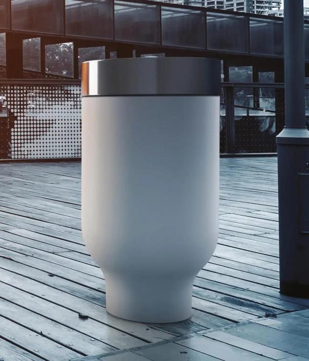 Moderne Abfalltonne mit schlichter, runder Form auf einer Holzdiele in einem urbanen Umfeld.
