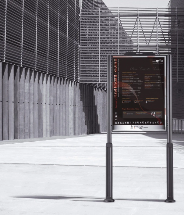 altus-hinweistafel-02 Modernes Hinweisschild, welches zwischen zwei Pfosten angebracht ist und vor einem modernen Gebäude steht.