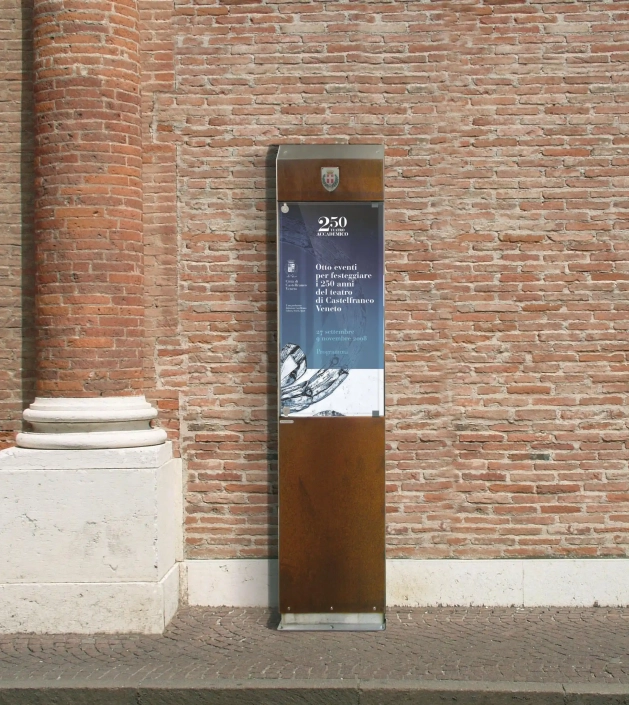 annunci-hinweistafel-06 Hinweisschild aus Metall mit Informationen zur 250-Jahr-Feier, platziert vor einer Backsteinmauer.