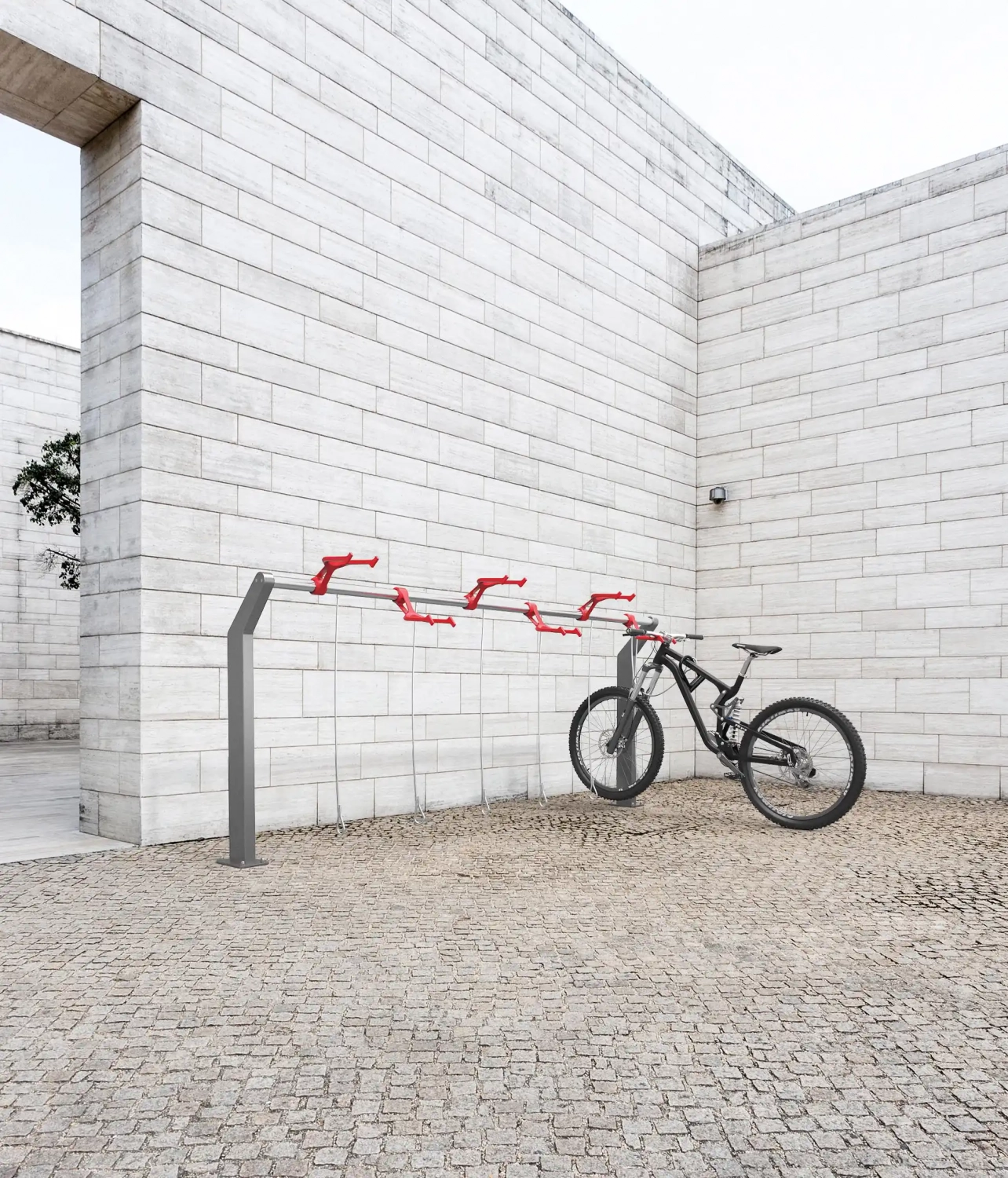 Alt-Text: "Moderne Fahrradabstellanlage mit roten Fahrradständern und einem Mountainbike in einem minimalistischen Innenhof."