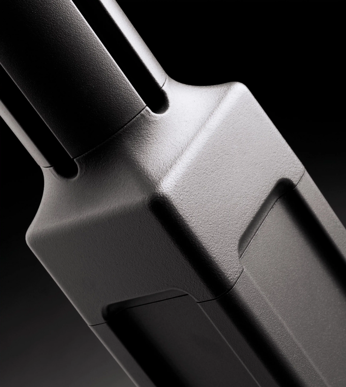 Alt-Text: Nahaufnahme eines Hinweisschildes aus grauem Kunststoff auf schwarzem Hintergrund.