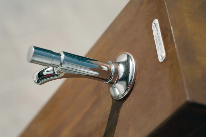 Alt-Text: Trinkwasserbrunnen aus Edelstahl mit holzähnlicher Umrandung in einem urbanen Raum.