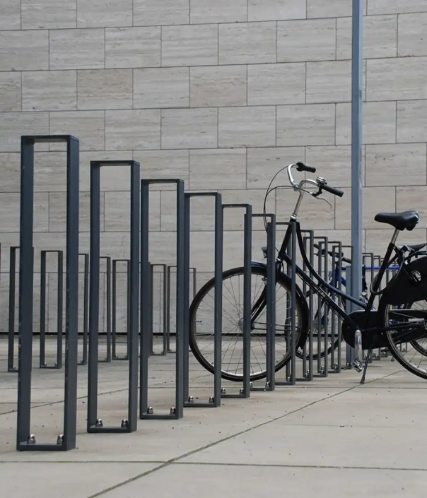 sv-c4-radverkehr-07 Alt-Text: "Fahrradständer in moderner Gestaltung, mit einem geparkten Fahrrad daneben."